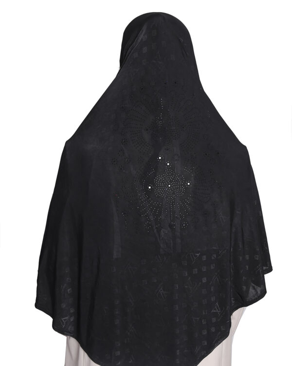 A woman modeling a Black Patterned Embellished Hijab, viewed from the side, highlighting the subtle square pattern and the rhinestone embellishment on the cap area.