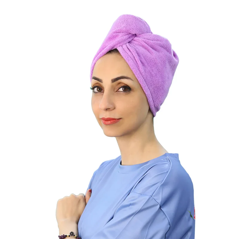 A detail shot of a woman with the Soft Microfiber Hair Drying Turban on, demonstrating the secure loop being attached to the button at the nape of the neck.