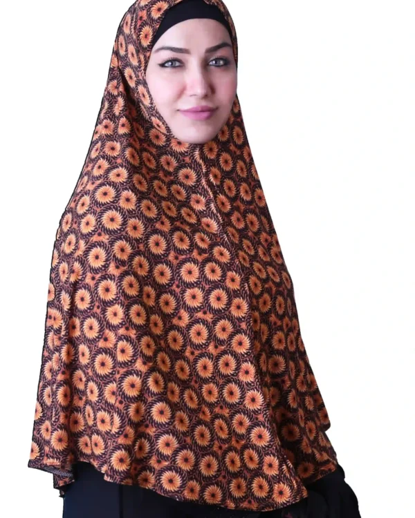 A woman models a Black & Orange Sunburst Rayon Hijab, looking straight at the camera with her hands clasped, emphasizing the full coverage and comfortable fit.