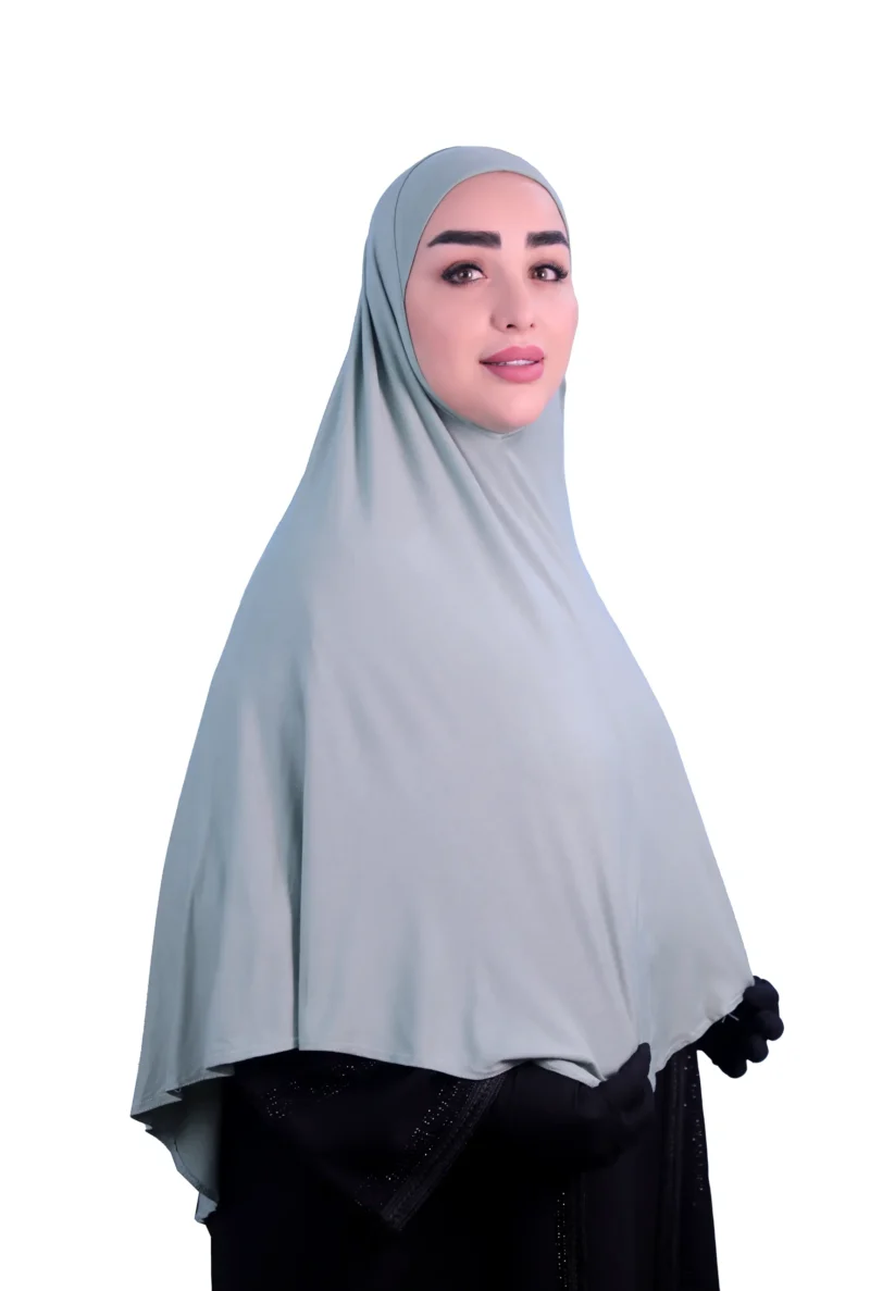 A woman models a Sage Green Cotton Hijab for Women, shown from the back to highlight the graceful flow of the fabric and the full-coverage design.