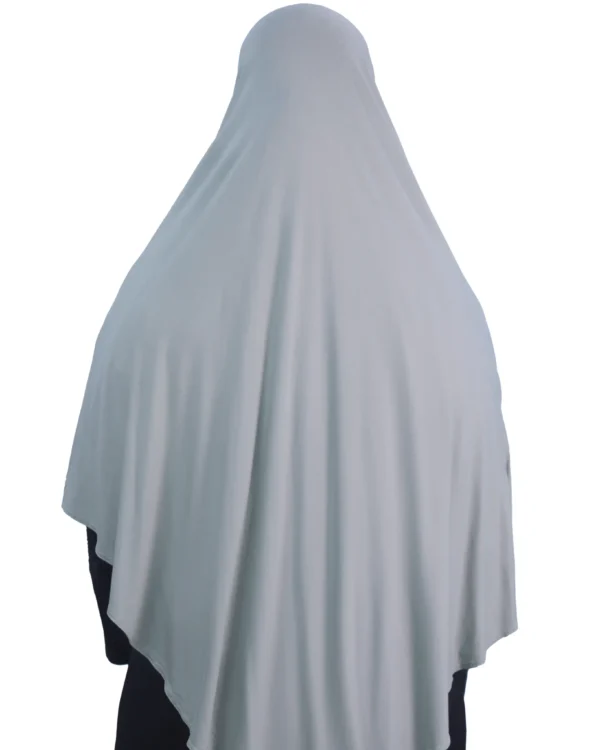 A woman models a Sage Green Cotton Hijab for Women, posing from the side to showcase the soft, lightweight material and elegant drape.