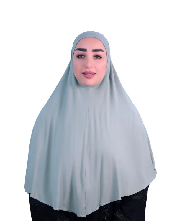 A woman models a Sage Green Cotton Hijab for Women, facing forward with a gentle smile, emphasizing the comfortable fit and simple, elegant style of the hijab.