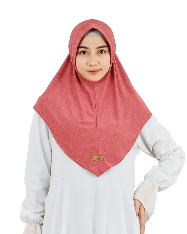 A woman models a Dusty Rose Chevron Hijab, posing at an angle to showcase the texture, the elegant drape, and the decorative braid detail at the top.