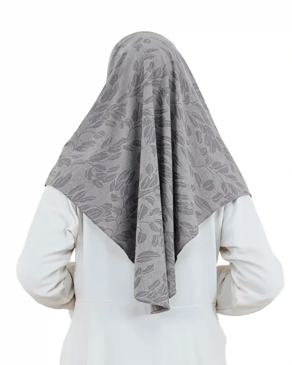 A woman models a Chic Grey Hijab with Leaf Pattern, facing forward and smiling slightly, highlighting the ready-to-wear style and the elegant tone-on-tone leaf motif.