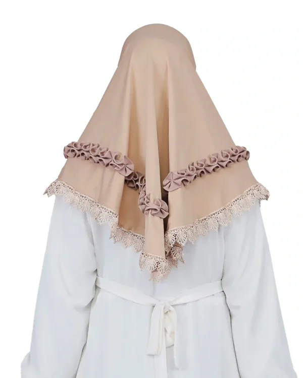 A woman models an Elegant Beige Ruffled and Lace Hijab, viewed from the side, emphasizing the texture of the ruffle details and the graceful flow of the fabric.