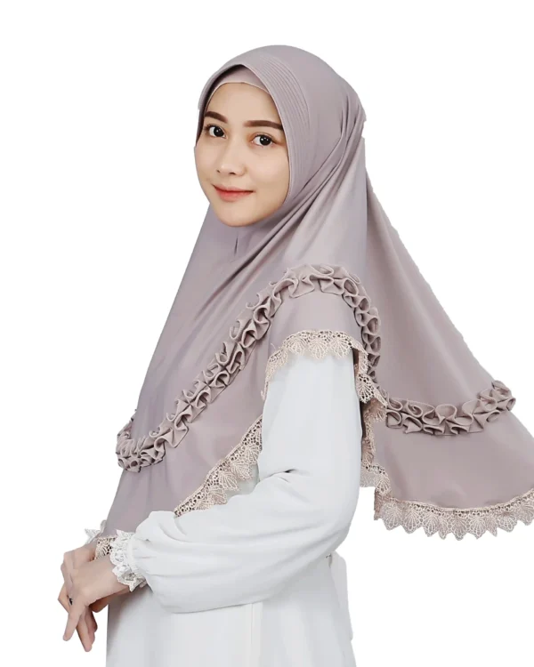 A woman models a Mauve Grey Ruffled and Lace Hijab, viewed from the side, emphasizing the soft fabric, the comfortable fit, and the stylish ruffles and lace trim.