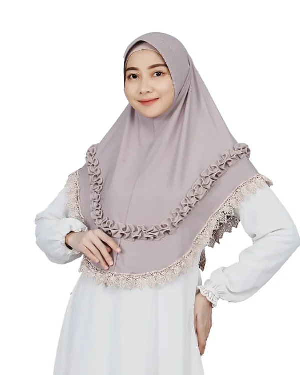 A woman models a stunning Mauve Grey Ruffled and Lace Hijab, facing forward and smiling, highlighting the decorative lace trim and the ruffled layers across the chest.